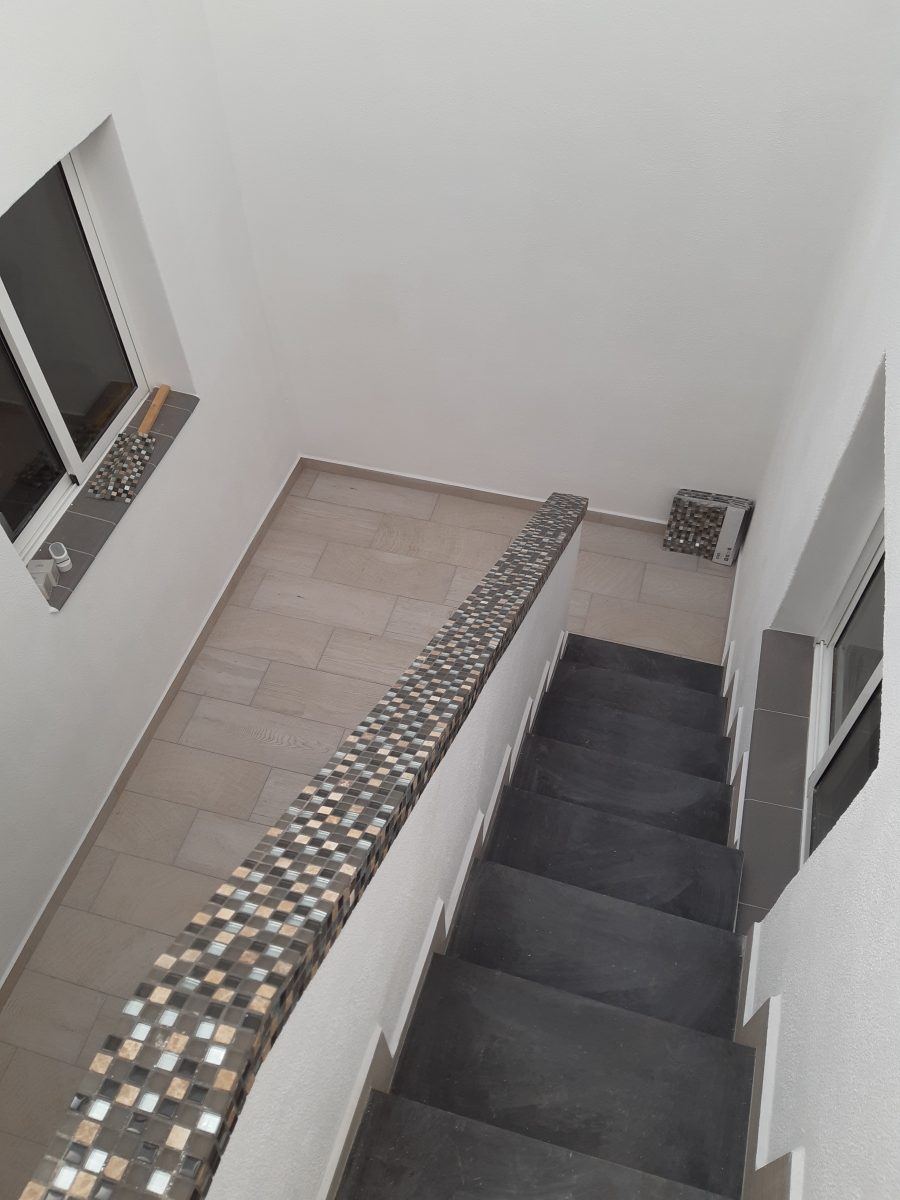 Escalera interior después de la reforma, con remate de mosaico