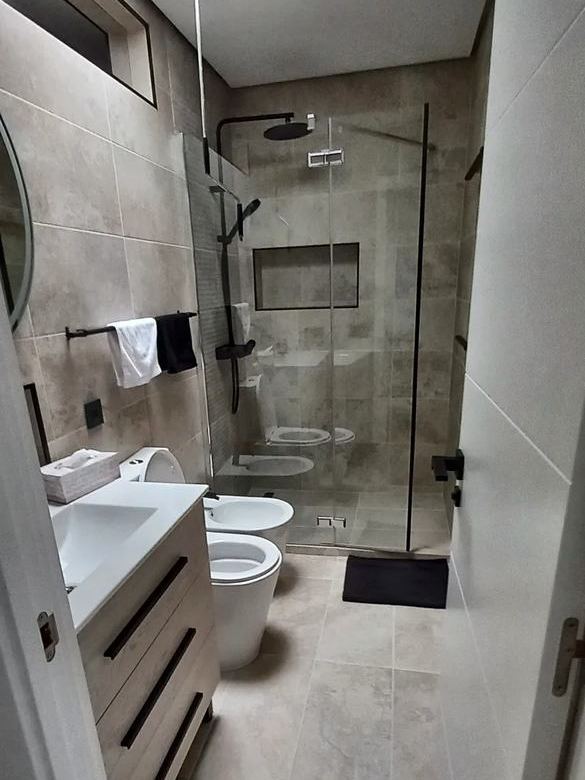 Baño terminado con ducha de obra y mampara de cristal